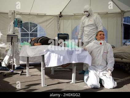 KIEV, UCRAINA - 12 ottobre 2021: Gli attivisti si esibiscono con una scena di rianimazione temporanea per i pazienti COVID-19. Decesso di un paziente Foto Stock