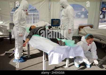 KIEV, UCRAINA - 12 ottobre 2021: Gli attivisti si esibiscono con una scena di rianimazione temporanea per i pazienti COVID-19. Decesso di un paziente Foto Stock