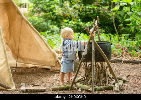 Bei bambini, fratelli, campeggio nella foresta, camino e tenda Foto Stock