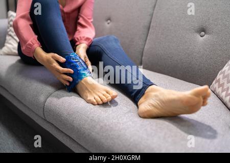 Donna che tiene gling gel terapia Pack dopo lesioni alle gambe Foto Stock