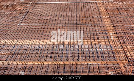 Costruzione aste industriali in acciaio struttura legata a filo primo piano per calcestruzzo cemento versato su pavimento piattaforma esterna edificio. Foto Stock