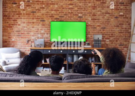 La famiglia guarda la TV a casa sul divano. Foto Stock