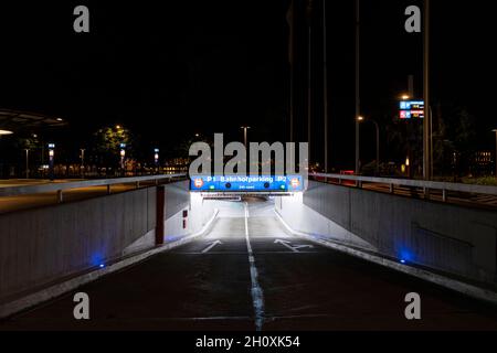 Ingresso parcheggio sotterraneo con iscrizioni tedesche a Luzern. Vista notturna, illuminata da luci. Segnaletica stradale a terra. Nessuno dentro Foto Stock