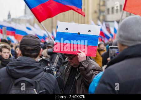 Mosca, Russia. 24 Feb 2019. Un dimostratore con una finta sparata attraverso la bandiera russa visto durante il marzo.migliaia di persone marciarono a Mosca in memoria del leader dell'opposizione Boris Nemtsov, che fu assassinato il 27 febbraio 2015. Oltre ai tradizionali attivisti liberali per questa azione, alla marcia hanno partecipato libertari, nazionalisti e il movimento ''decomunizzazione' di Dmitry Enteo. (Credit Image: © Mihail Siergiejevicz/SOPA Images via ZUMA Press Wire) Foto Stock