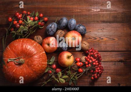 mele e altri frutti su sfondo di legno scuro in stile rustico Foto Stock