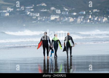 Tre body board surfisti sulla spiaggia a Putsborough, nel Devon settentrionale, la mattina di ottobre. Foto Stock