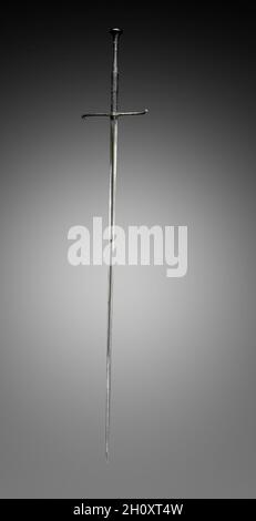Estoc, primi del 1500. Germania, inizio del 16 ° secolo. Acciaio, legno e pelle; tuta: 156.6 cm (61 5/8 in.); lama: 125.3 cm (49 5/16 in.); quillioni: 26.2 cm (10 5/16 in.); impugnatura: 30 cm (11 13/16 in.). La parola francese estoc significa 'spinta? E quindi è stato adottato come il nome di questa lunga spada di spinta. Ha una presa abbastanza lunga e un'ilt a forma di croce semplice. La lama rigida, progettata per la spinta contro gli avversari corazzati, è a tre lati per la forza. L'estoc è stato talvolta trasportato dalla sella. Dai primi del 1300, fu usato dai cavalrymen come braccio laterale ausiliario quando un cavaliere aveva il dismo Foto Stock