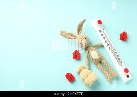 Concetto di stagione di riscaldamento con coniglio giocattolo su sfondo blu. Foto Stock