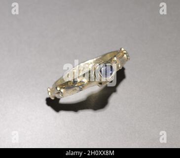 Anello, 1300. Inghilterra, 14 ° secolo. Argento dorato, zaffiro; diametro: 2.9 cm (1/8 poll.). La tradizione sostiene che questo anello è stato trovato in un giardino a Winchester, Inghilterra. Nel 14 ° secolo, gli anelli sono stati indossati in grandi numeri-quattro o cinque su una mano. I simboli del sole e della luna e le mani aggrappate che si trovano su questo anello suggeriscono una relazione sentimentale tra un uomo e una donna. Foto Stock