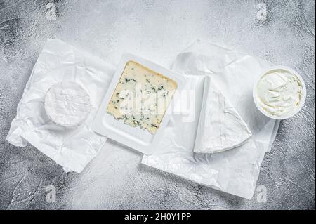 Varietà di formaggi su tavola da cucina, brie, Camembert, Gorgonzola e formaggio cremoso blu. Sfondo bianco. Vista dall'alto Foto Stock