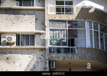 Beirut, Libano. 15 ottobre 2021. Un edificio è stato avvistato di buchi di proiettili nella zona di Tayouneh, a seguito dei violenti scontri di ieri tra militanti sciiti musulmani di Hezbollah pro-iraniano e avversari. Almeno sei persone sono state uccise e 32 altre sono state ferite a Beirut oggi in colpi di arma da fuoco e scontri per una protesta contro un giudice che indaga l'esplosione massiccia dell'anno scorso al porto della città. Credit: Marwan Naamani/dpa/Alamy Live News Foto Stock