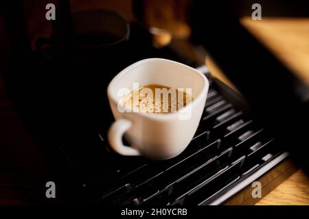 Preparazione di una tazza di caffè utilizzando una macchina espresso in un caffè, macchina da caffè preparazione di caffè espresso Foto Stock