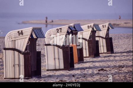 Sedie da spiaggia in vimini con tetto nella luce della sera sulla spiaggia di Ahrenshoop, penisola di Darß Foto Stock