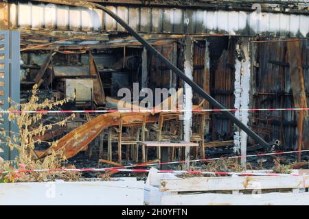 Casa bruciata con tetto carred e mobili bruciati. Foto Stock