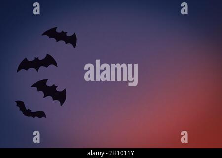 Piccoli giocattoli neri su sfondo blu scuro. Concetto di Halloween Foto Stock