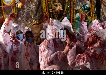 Kolkata, India. 15 ottobre 2021. I devoti indù che indossano dispositivi di protezione individuale applicano 'indhur', o vermillion polvere l'uno sull'altro dopo aver adorato l'idolo indù dea Durga l'ultimo giorno del festival Durga Puja a Kolkata. (Foto di Sudipta Das/Pacific Press) Credit: Pacific Press Media Production Corp./Alamy Live News Foto Stock