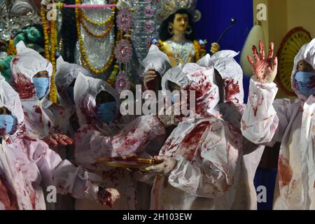 Kolkata, India. 15 ottobre 2021. I devoti indù che indossano dispositivi di protezione individuale applicano 'indhur', o vermillion polvere l'uno sull'altro dopo aver adorato l'idolo indù dea Durga l'ultimo giorno del festival Durga Puja a Kolkata. (Foto di Sudipta Das/Pacific Press) Credit: Pacific Press Media Production Corp./Alamy Live News Foto Stock