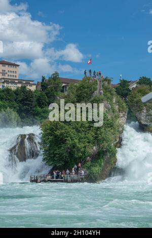 Schaffhausen, Germania - 9 agosto 2021: Piattaforma turistica direttamente sulle acque selvatiche delle Cascate del Reno Foto Stock