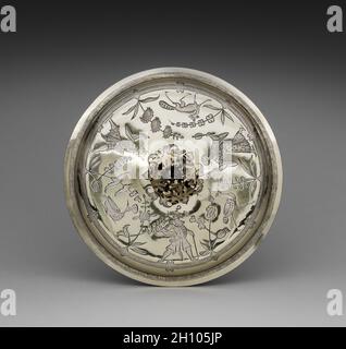 Coperchio per una tazza a due maneggiate, 1686. Inghilterra, Londra, XVII secolo (Giacomo II). Dorato argento; totale: 23.9 x 32.4 cm (9 7/16 x 12 3/4 pollici). Prodotto un anno dopo l'incoronazione di Giacomo II (1633-1701), questo coperchio e il calice accompagnatore celebrano la monarchia e riflettono le alleanze politiche e sociali che hanno sostenuto l'aristocrazia durante il 1600. Durante la loro incoronazione, Giacomo II e la sua seconda moglie Maria di Modena (1658-1718) furono trasportati attraverso la città di Londra sotto un baldacchino di seta adornato da motivi ispirati alle percezioni europee dell'arte cinese, nota come chinoiserie. Seguendo il Foto Stock