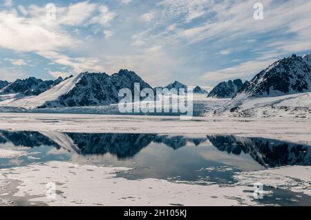 Ghiacciaio di Monaco e la sua riflessione specchio sulle acque artiche. Ghiacciaio di Monaco, Isola di Spitsbergen, Svalbard, Norvegia. Foto Stock