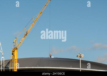 Un lavoratore sul tetto dell'OVO Hydro a Glasgow come lavoro di preparazione è ben in corso per preparare le sedi della città ospitante per le Nazioni Unite COP26. Foto Stock