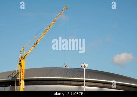 Un lavoratore sul tetto dell'OVO Hydro a Glasgow come lavoro di preparazione è ben in corso per preparare le sedi della città ospitante per le Nazioni Unite COP26. Foto Stock