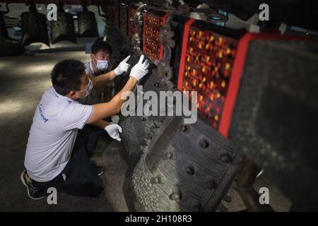 (211015) -- WUHAN, 15 ottobre 2021 (Xinhua) -- i membri del personale aggiustano le campane del suono dopo che sono state trasferite ad una sala di esposizione di nuova costruzione del Museo Provinciale di Hubei in Wuhan, provincia centrale di Hubei della Cina, 15 ottobre 2021. Il set di campane di carillon è stato recentemente rilocato al nuovo progetto della terza fase del museo. Credit: Xinhua/Alamy Live News Foto Stock