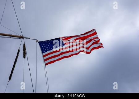 Bandiera nazionale degli Stati Uniti d'America, che batte nel vento sull'albero della nave. Foto Stock