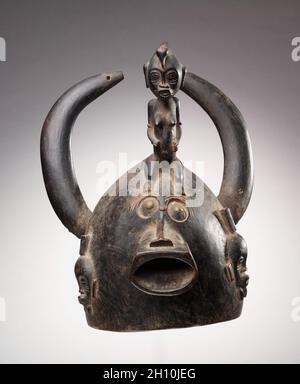 Maschera casco, primi a metà del 1900. Africa, Africa occidentale, Côte d'Avorio, carver in stile senufo. Legno, borchie per tappezzeria e colorante; totale: 34.9 cm (13 3/4 poll.). Foto Stock