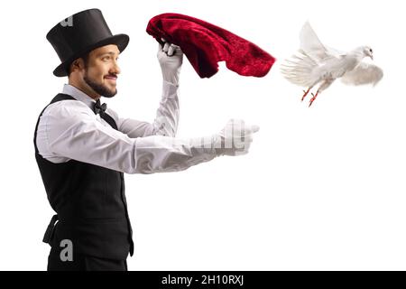 Mago che esegue un trucco e una colomba bianca che vola dalla sua mano isolato su sfondo bianco Foto Stock
