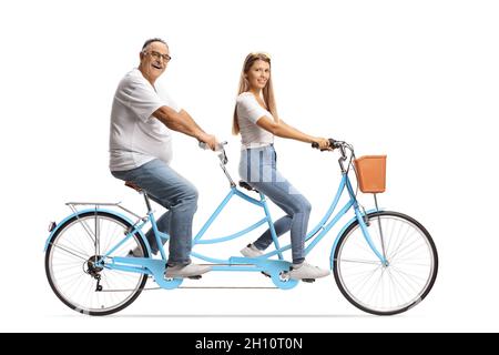 Giovane donna e uomo maturo in magliette bianche e jeans a cavallo di una bicicletta tandem isolata su sfondo bianco Foto Stock