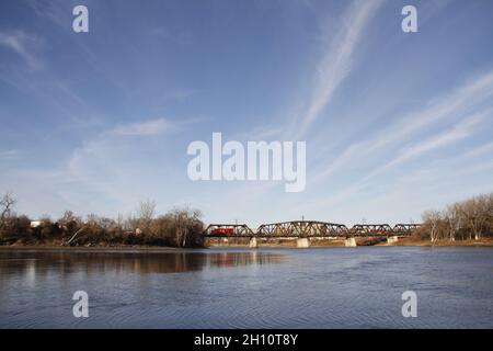 Vista di un treno che attraversa un ponte su un corpo d'acqua, Winnipeg, Manitoba Foto Stock