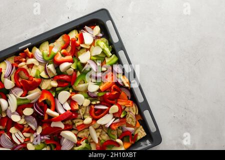 Verdure fresche e assortite tagliate in autunno su un foglio da forno pronto per arrostire in forno Foto Stock