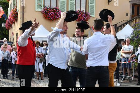 Uomini che suonano cappelli musicali con gruppo di ballo folk alsaziano nel villaggio di Turkheim durante la vendemmia alsaziana 2021 Foto Stock