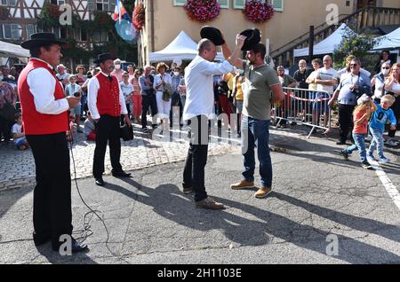 Uomini che suonano cappelli musicali con il gruppo tradizionale di ballo folk alsaziano nel villaggio di Turkheim durante la vendemmia alsaziana 2021 Foto Stock