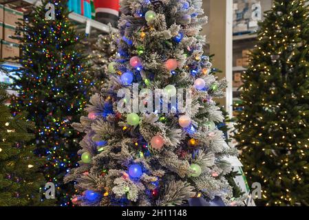 Decorazioni di Natale in vendita in un deposito domestico di miglioramento, Florida del nord. Un albero di Natale completamente decorato è in vendita, completo di luci. Foto Stock