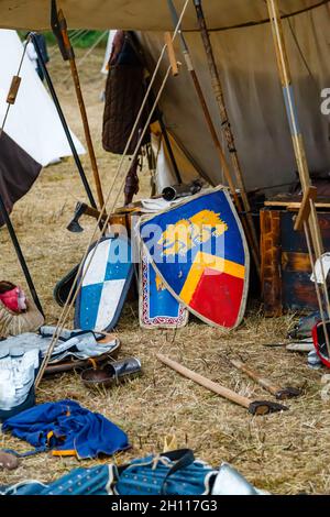 Vari scudi medievali e armature in una tenda da campeggio Foto Stock