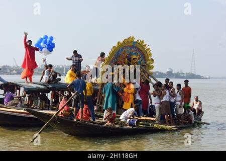 Kolkata, India. 15 ottobre 2021. Devoti sulle barche che prendono un idolo per l'immersione, durante il rituale. Gli idoli di Durga sono stati immersi in diversi ghati a Kolkata durante Dasami, che è l'ultimo dei 4 giorni di festa di Durga puja quando gli idoli sono immersi nel fiume Ganga. (Foto di Sumit Sanyal/SOPA Images/Sipa USA) Credit: Sipa USA/Alamy Live News Foto Stock