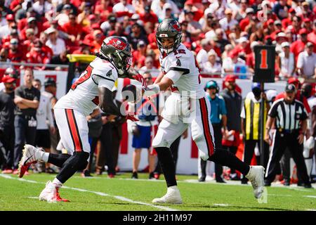 Tampa, Stati Uniti. 10 Ott 2021. Tampa Bay Buccaneers quarterback Tom Brady (12) passa la palla a correre Ronald Jones (27) nel secondo trimestre contro i Miami Dolphins al Raymond James Stadium, domenica 10 ottobre 2021 a Tampa, Florida. (Foto di Martha Asencio-Rhine/Tampa Bay Times/TNS/Sipa USA) Credit: Sipa USA/Alamy Live News Foto Stock