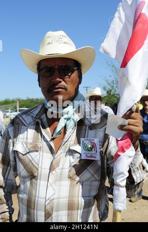Un uomo Mayo indossa jeans e occhiali da sole mentre porta la bandiera del CONSUC, IL CONSIGLIO NAZIONALE DELLE SOCIETÀ E DELLE UNITÀ CON CONTADINI E COLONI. Residenti della comunità Agiabampo, sonora, Messico. Agiabampo è una ranchería del comune di Huatabampo situata nel sud dello stato messicano di sonora ... (Foto di Isrrael Garnica / NortePhoto) un hombre Mayo viste vaquero y lentes de sol mientras porta la bandera CONSUC, CONSEJO NACIONAL DE SOCIEDADES Y UNIDADES con CAMPESINOS Y COLONOS. Pobladores de la comunidad Agiabampo, sonora, Messico. Agiabampo es una ranchería del Municipio d Foto Stock