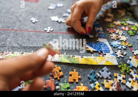 Mano che dà sostegno dando un pezzo di puzzle, collegando insieme puzzle. Concetto di progetto di gruppo. Successo e strategia e concetto di partner Foto Stock