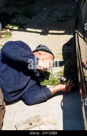 Primo piano di cambio meccanico ruota su auto con utensile manuale in Romania, Bucarest, 2022 Foto Stock