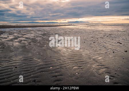 Tramonto sull'isola di Arran, visto dalla spiaggia di Irvine, Scozia. Foto Stock