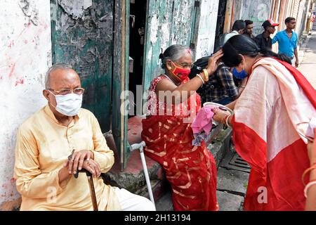 Kolkata, India. 15 ottobre 2021. Una vecchia donna che esegue rituale con un altro devoto l'ultimo giorno di Durga Puja a Kolkata. (Foto di Suraranjan Nandi/Pacific Press) Credit: Pacific Press Media Production Corp./Alamy Live News Foto Stock