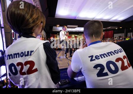 Nimes, Francia. 15 ottobre 2021. Eric Zemmour è visto sul palco con il titolo del suo libro 'la France n'a pas dit son dernier mot' proiettato su uno schermo dietro di lui. L'estrema destra polemista Eric Zemmour ha attirato più di 1500 persone a Nimes (Francia). Ha tenuto un discorso come candidato senza confermare ufficialmente che correrà per il presidente nel 2022. I membri della campagna "Gioventù con Zemmour" hanno distribuito materiali per la campagna, tra cui le magliette "Zemmour 2022". Ha annunciato di voler "mettere fine all'immigrazione illegale e legale” e ha criticato con forza il comportamento della tradizionale destra Foto Stock