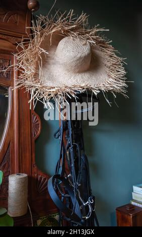 I finimenti dei cavalli e il cappello di paglia in una casa vintage Foto Stock