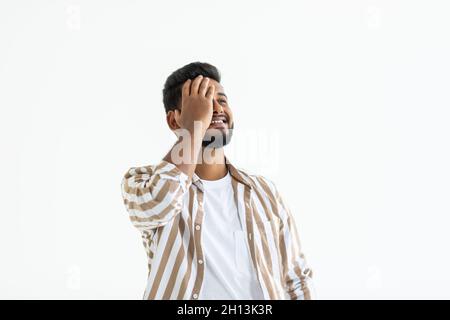 Giovani indiani uomo che indossa la t-shirt in piedi isolato su sfondo bianco che soffrono di mal di testa disperato e ha sottolineato perché il dolore e l'emicrania. Han Foto Stock