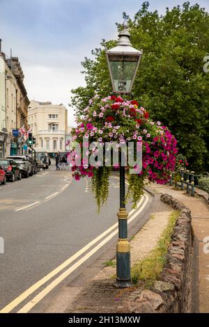 Regno Unito, Inghilterra, Worcestershire, Great Malvern, Bellevue Terrace, luce stradale a gas con cesto appeso floreale Foto Stock