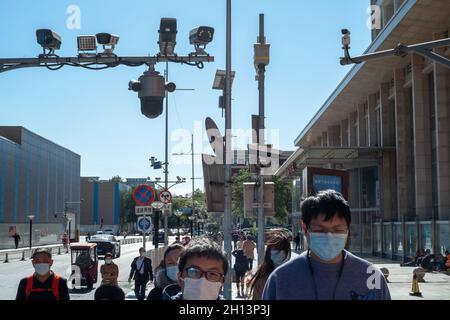I pedoni camminano sotto le telecamere CCTV in via Wangfujing a Pechino, Cina. 16 ottobre 2021 Foto Stock