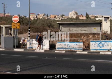 I soldati israeliani si trovano dietro blocchi di cemento in una stazione di hitchhiking in un incrocio vicino all'insediamento ebraico di Ariel il 14 ottobre 2021 in Cisgiordania, Israele. Attualmente, la maggior parte della Cisgiordania è amministrata da Israele anche se il 42% di essa è sotto vari gradi di autonomia da parte dell'autorità palestinese gestita da Fatah. Foto Stock